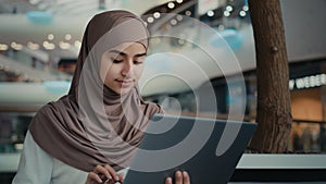 Islamic arabian muslim businesswoman in hijab female entrepreneur student girl woman working at shopping mall use laptop