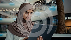 Islamic arabian muslim businesswoman in hijab female entrepreneur student girl woman working at shopping mall use laptop