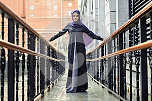 Islamic beautiful woman in a Muslim dress standing on a European street