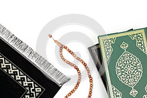 Islamic Holy Book Quran with rosary beads and prayer rug on isolated white background. Kuran the holy book of Muslims. Ramadan con photo