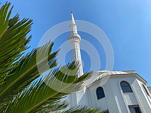 Islamic mosque new modern white arabic large muslim for prayers with a high tower in a tourist warm tropical eastern country
