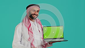 Islamic person shows greenscreen laptop