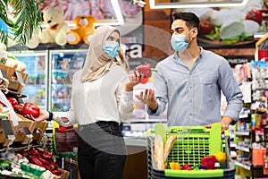Islamic Spouses Doing Grocery Shopping Buying Fresh Vegetables In Supermarket