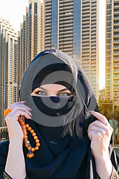 Islamic woman on the background of tall modern business buildings