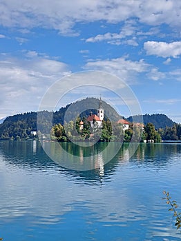 island with church under blue sky with white clouds. Slovenia. Lake Bled