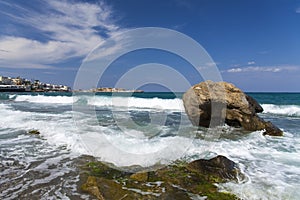 Island of Crete in Greece. Blue sea and rock on the background of the city.