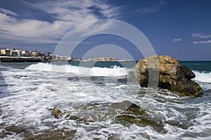 Island of Crete in Greece. Blue sea and rock on the background of the city.