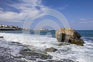 Island of Crete in Greece. Blue sea and rock on the background of the city.