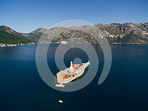 Island of Gospa od Skrpjela in the Kotor Bay with mountains in the background. Montenegro