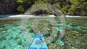 Island hopping Tour boat approaching exotic remote beach on travel trip exploring Bacuit archipelago, El Nido