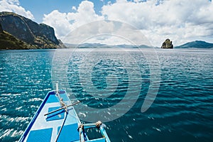 Island hopping Tour boat hover over blue ocean between exotic islands on excursion trip exploring Bacuit archipelago, El