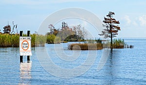 Island in Lake Pontchartrain with NO WAKE sign