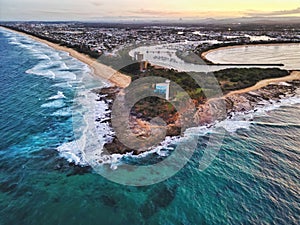 an island with a lighthouse on it's right next to a city