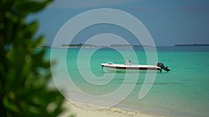 Island In Maldives - Boat Floating Over The Crystal Clear Sea Water. near the beach. Sunny day in paradise. Many island