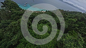 Island mountain rainforest speed dive from top sea beach lagoon bangka boat palm trees aerial view