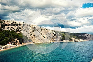 Island on ocean or sea. tropical destination. Landscape wallpaper with exotic beach, dramatic cloudy sky and blue water.