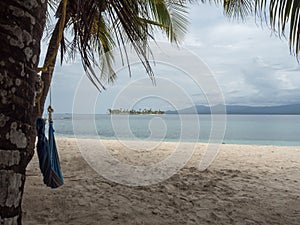 Island view from another island, with a hammock and palm trees at san blas panama