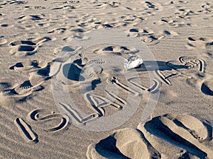 ISLANDA handwriting on black sand beach, Iceland