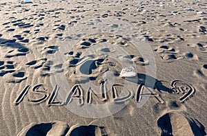 ISLANDA handwriting on black sand beach, Iceland