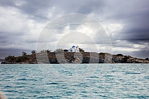 Islet of Agia Kali with chapel in front of Naoussa village Paros island Cyclades Greece