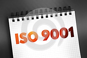 ISO 9001 - international standard that specifies requirements for a quality management system, text concept on notepad