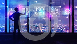 ISO 9001 with man by large windows at night