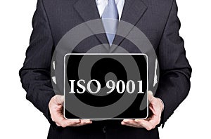 ISO 9001 written on virtual screen. technology, internet and networking concept. man in a business suit and tie holds a