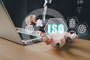 ISO standards quality control concept, Person hand holding iso icon on virtual screen on desk workplace, Assurance warranty,