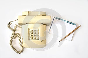 Isolate beige old telephone with wire tube lies on white background
