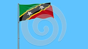 Isolate flag of Saint Kitts and Nevis on a flagpole fluttering in the wind on a blue background, 3d rendering