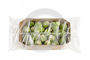 Isolate of fresh Brussels sprouts in paper wrapping and a transparent plastic bag. Brussels sprouts in transparent