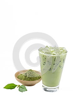 Isolate Iced Green Tea latte matcha on white background with crushed tea extract powder in wooden cup and leaves. The most