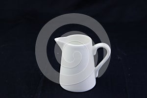 Isolate pouring milk, tea pot ,kettle on black background.