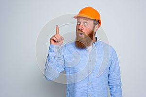 Isolated amazed architect with beard and orange helmet