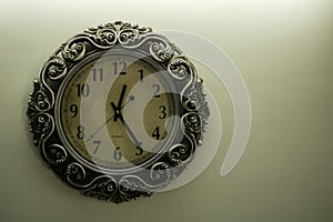 Isolated Ancient Designer Wall Clock With Light Yellow Back Ground showing time 12:25 o`clock and free spac on right side