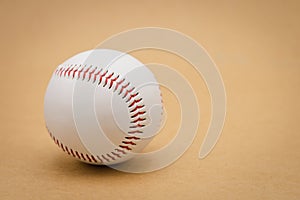 Isolated baseball on a brown background and red stitching baseball. White baseball with red thread.Baseball is a national sport of