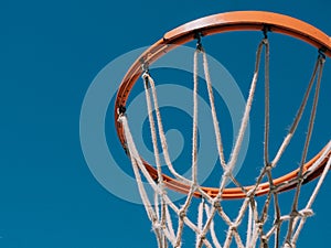 Isolated basketball net shot directly below and looking up with the blue sky as the background