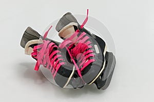 Isolated black old-fashion hockey skates with pink bootlace