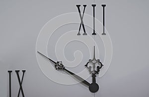 Isolated black wall clock hands and roman numbers interior object on white background