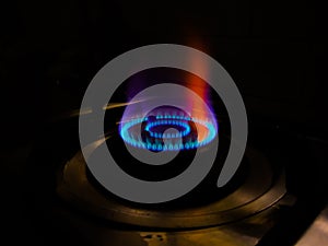 Isolated blue flame with orange shade of gas burner at black background