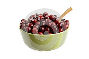 Isolated bowl of cranberries with wood spoon on white