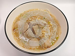 isolated bowl of meatball soup with sliced ??celery leaves and fried shallots