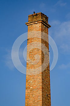 isolated brick chimney of an old industrial building