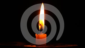 An isolated burning candle flame on a black background