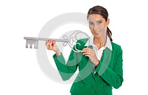 Isolated business woman in green holding key for dedicate a house.
