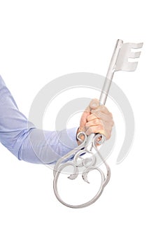 Isolated businessman holding a silver key in his hand.