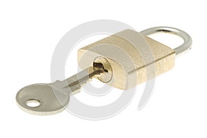 Isolated closed brass padlock with key about to op