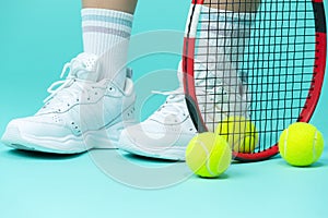 Isolated Closeup on Legs of Caucasian Female Tennis Player Grasping Tennis Ball With Racket. Over Blue