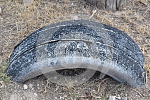 Isolated closeup of used tire buried in ground