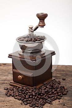 Isolated coffee bean grinder next to fresh coffe bean